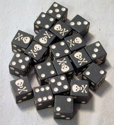 black dices with white skulls and crossbones are arranged on a tablecloth