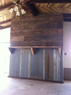 a ceiling fan mounted on top of a wooden wall next to a metal structure with corrugated coverings