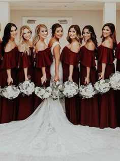 a group of women standing next to each other in front of a white door wearing dresses