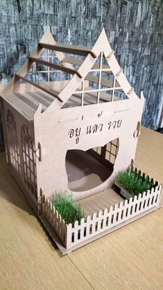 a paper model of a house with grass growing out of it