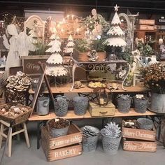 an assortment of christmas items on display in a store with wooden crates and metal buckets