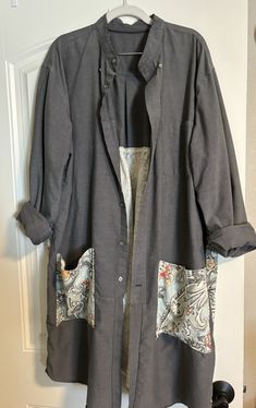 a jacket hanging up on a door with an open front and two pockets in the back