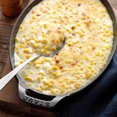 a skillet filled with macaroni and cheese on top of a wooden cutting board