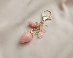 a pair of pink flowers and pearls on a gold plated keychain