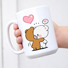 a person holding a coffee mug with a cartoon bear on it