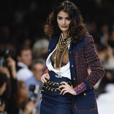 a woman is walking down the runway with her hand on her hip and wearing a jacket