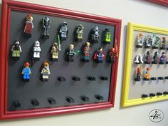 lego minifigures are displayed on the wall next to each other in a red frame