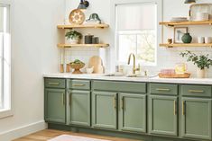 a kitchen with green cabinets and wooden shelves