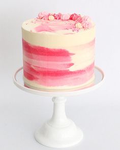 a cake with pink and white frosting on a plate