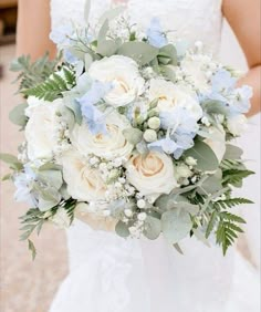 a bridal holding a bouquet of white and blue flowers