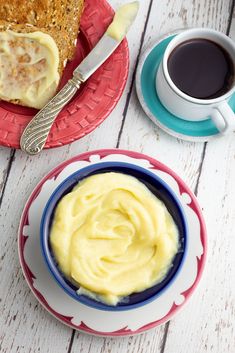 two plates with food on them next to a cup of coffee and a plate with cake