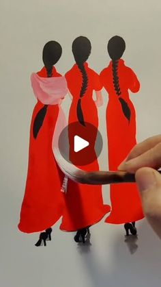 someone is cutting out an image of three women in red dresses