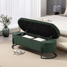 an open suitcase sitting on the floor in front of a bed with slippers next to it