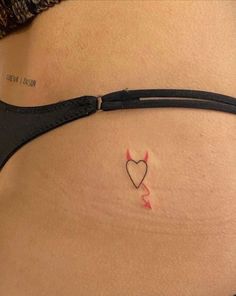 a woman's stomach with a small heart tattoo on the side of her belly