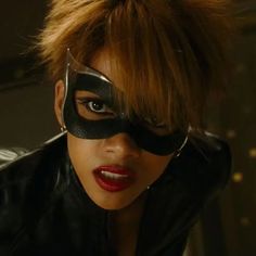 a woman wearing a black mask and red lipstick