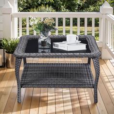 a coffee table sitting on top of a wooden deck next to a planter filled with flowers