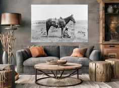 a living room filled with furniture and a painting on the wall above it's coffee table