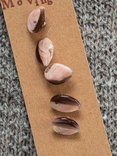 three rocks sitting on top of a piece of cardboard