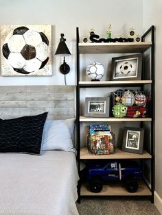 a bedroom with a bed, bookshelf and pictures on the wall above it