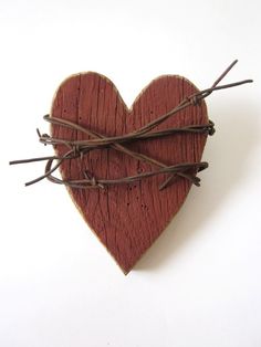 a wooden heart with barbed wire in the shape of a heart on a white background