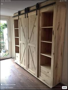 an empty room with wooden shelves and sliding doors