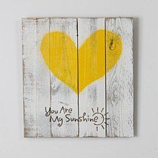 a yellow heart painted on wood with words written in black and white, that says you are my sunshine