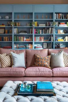 a living room filled with lots of bookshelves next to a couch and coffee table