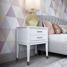 a bedroom with a bed, nightstand and colorful wallpaper