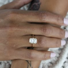 a woman's hand with a diamond ring on it