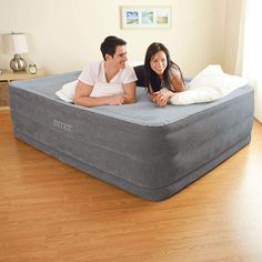 a man and woman laying on top of an inflatable mattress