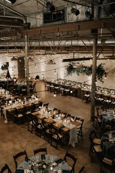 a large room filled with lots of tables covered in white tablecloths and candles