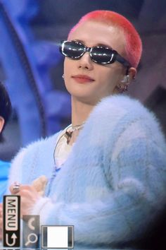 a woman with pink hair wearing sunglasses and a fur coat on the set of tv show