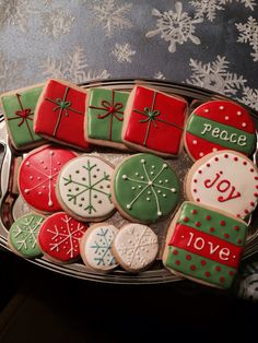 decorated christmas cookies in a metal tray on a table with snowflakes and ribbons