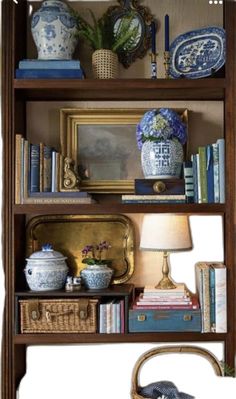 a book shelf with books, vases and other items on it's shelves