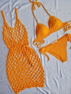 two pieces of yellow crochet swimsuit on a white sheet with orange string