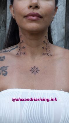 a woman with tattoos on her chest wearing a white dress and looking at the camera