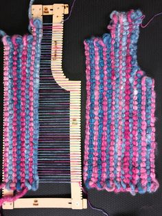 a close up of a weaving machine with pink and blue yarn on the back side