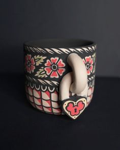 a black and white bracelet with red flowers on it