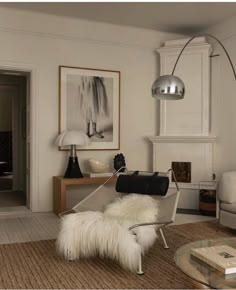 a living room with a chair, lamp and pictures on the wall