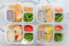 four plastic containers filled with food on top of a marble countertop next to green beans and apples