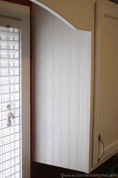 an open cabinet door in a kitchen with blinds