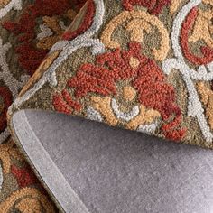 a close up view of the corner of a couch with a decorative pattern on it