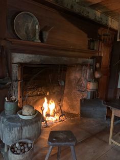 an old fireplace with logs and pots on it