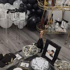 a room filled with black and white balloons, pictures, and other items on the floor