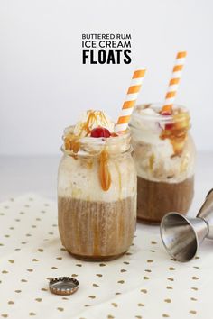 two desserts with strawberries and whipped cream in small jars on a white table