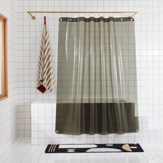 a bathroom with a shower curtain next to a window