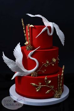 a three tiered red cake with white birds on it