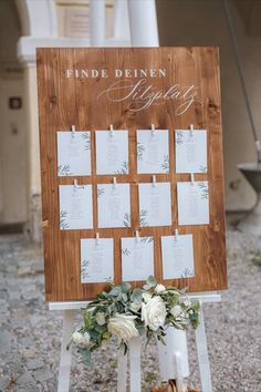 a wooden sign with seating cards attached to it