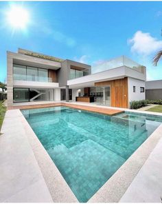 an empty swimming pool in front of a modern house