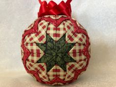 a red and white ornament with a green star on it